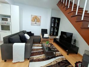 a living room with a couch and a television at Faial Inn in Horta +18 photos
