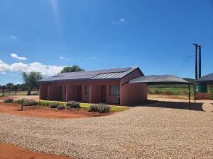 a small red building with a black roof at Zondereinde Accommodation in Wag ʼn Bietjie Draai