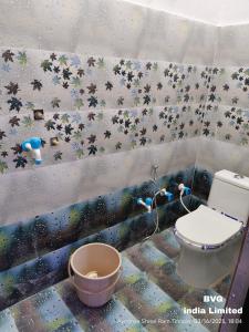 a bathroom with a toilet and a wall with stars at प्रभु श्रीराम नगरी गेस्ट हाउस in Ayodhya