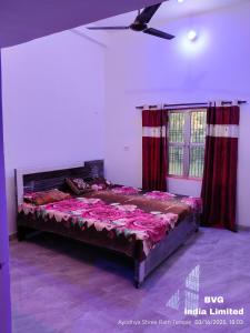 a bedroom with a large bed with red curtains at प्रभु श्रीराम नगरी गेस्ट हाउस in Ayodhya
