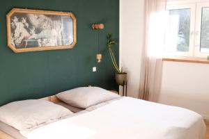 a bed in a room with a green wall at FEWO Silberberg in Dornstetten