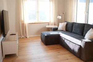 a living room with a couch and a television at FEWO Silberberg in Dornstetten