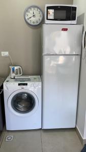 microondas en la parte superior de una nevera junto a una lavadora en Depto Magallanes, en Ushuaia