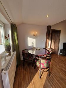 a living room with a dining room table and chairs at Ferienwohnungen Dümmersee - Haus Dümmerland - Wohnung 6 in Hüde