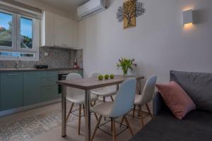 a kitchen and dining room with a table and chairs at Dream Suites in Vourvourou