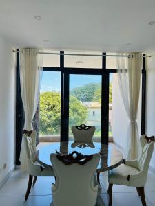 a dining room with a glass table and chairs at Flic en Flac Luxe Seascape in Flic-en-Flac +39 photos