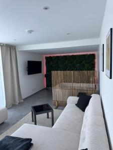 a living room with a white couch and a television at Romantik-Wohnung - Auszeit-Momente mit Sauna in Syke