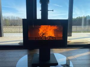 a fireplace with fire in it in front of a window at Black House Spithami in Spithami