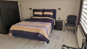 a bedroom with a large bed and a chair at MARINA in Houthalen-Helchteren