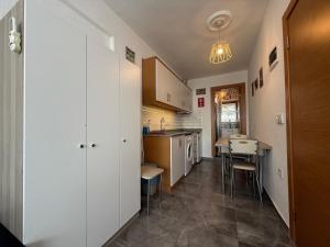 a kitchen with white cabinets and a table and chairs at Arslan Homes 3 in Marmaris +4 photos