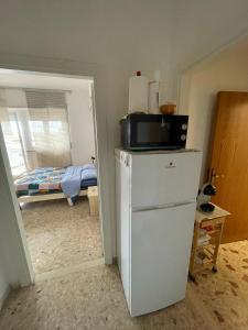 y cocina con nevera y microondas. en Affittacamere Santa Lucia, en San Benedetto del Tronto