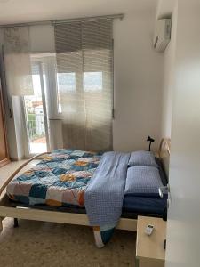 Un dormitorio con una cama en una habitación con ventana. en Affittacamere Santa Lucia, en San Benedetto del Tronto