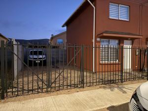 a fence in front of a house with a car parked at Julieta kirkwood in Coquimbo
