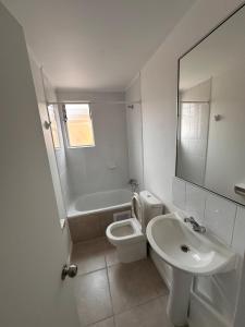 a bathroom with a sink and a toilet and a mirror at Julieta kirkwood in Coquimbo +23 photos