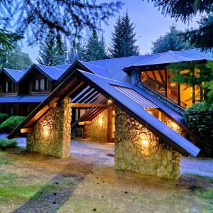 a house with a gambrel roof with lights on it at Altos Los Pioneros & Spa in Villa La Angostura