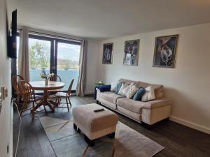 a living room with a couch and a table at Slough Luxhaven Elegant One-Bed Apartment on High Street in Slough
