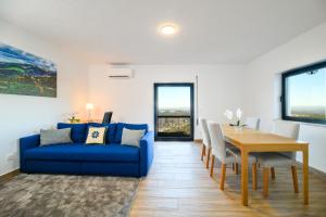 a living room with a blue couch and a table at Casa do Beco - Seia, Serra da Estrela in Lapa dos Dinheiros