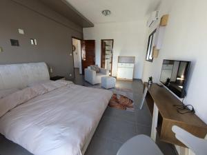 a bedroom with a large bed and a living room at Belle villa à Vohitsara,Tamatave in Toamasina