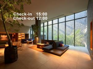 京都Mitsui Garden Hotel Kyoto Sanjo PREMIER的大厅,在大楼里长着长沙发和一棵树