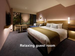 京都Mitsui Garden Hotel Kyoto Sanjo PREMIER的配有一张大床和一张书桌的酒店房间