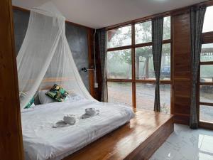 a bedroom with a bed with two tea cups on it at The Nanda Resort in Ban Huai Salok