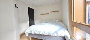 Una cama pequeña en una habitación con ventana. en Albaron - center of Bourg Saint Maurice, en Bourg-Saint-Maurice