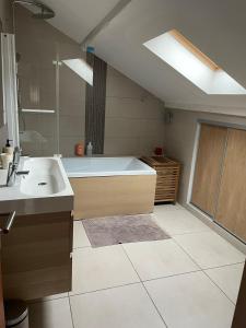 een grote badkamer met een bad en een wastafel bij Grande maison dans les Pyrénées in Argelès-Gazost