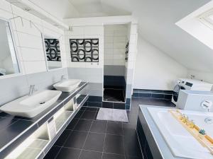 ein weißes Badezimmer mit zwei Waschbecken und einer Badewanne in der Unterkunft 23-schöner Wohnen, großes Apartment für 5-6 Personen in super Lage in Duisburg