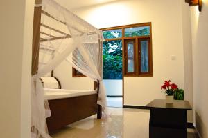 a bedroom with a bed with a mosquito net at Angel White in Unawatuna in Unawatuna