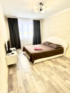 a bedroom with a bed and a television in it at Квартира 43 in Karagandy