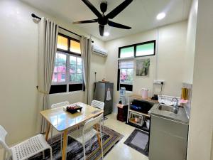 a kitchen with a table and a ceiling fan at Delima Traditional House in Changlun