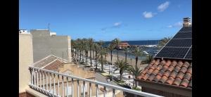 a balcony with a view of a street with palm trees at Casa Frijol 20metres from the beach in Los Alcázares