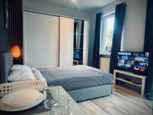 ein Schlafzimmer mit Bett, Tisch und Fernseher in der Unterkunft Studio 4U - Aquapark Reda in Reda