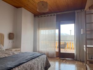 a bedroom with a bed and a sliding glass door at Magnifico ático con vistas, parking y piscina in Puigcerdà +32 photos