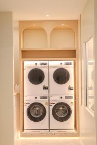 two washer and dryer machines in a room at ezzenhotel Phitsanulok in Phitsanulok