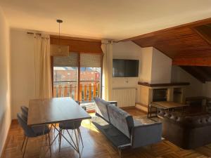 a living room with a couch and a table at Magnifico ático con vistas, parking y piscina in Puigcerdà