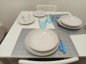 a table with white plates and glasses on it at La Primula Roma, a 15 minuti da San Pietro in Rome +3 photos