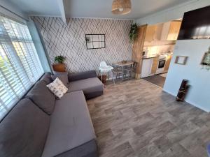 a living room with a couch and a kitchen at Norfolk Beach Chalet - California Sands Resort in Great Yarmouth