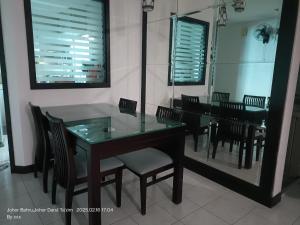 a dining room with a glass table and chairs at Furry Companion Stay at Larkin in Johor Bahru +9 photos