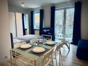 ein Wohnzimmer mit Tisch und Stühlen und ein Schlafzimmer in der Unterkunft Studio 4U - Aquapark Reda in Reda