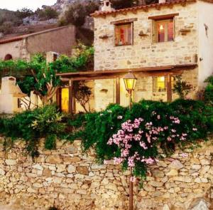a stone building with a street light and flowers at Climb and dive South ! in Kapetanianá