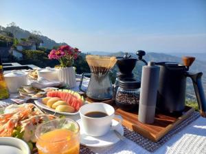 a table with a breakfast of fruit and coffee on it at Cozy Homey Doichang in Ban Muang Ngam