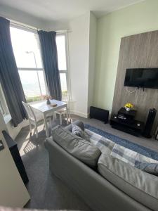 a living room with a couch and a table at Farina No5, Sea view studio sleeping 2 guests in Bridlington