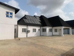 a white house with solar panels on the roof at Umbrella Properties hotels and apartments - Moniya in Ibadan