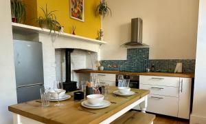 a kitchen with a wooden table with dishes on it at Zen Beach House in Kent