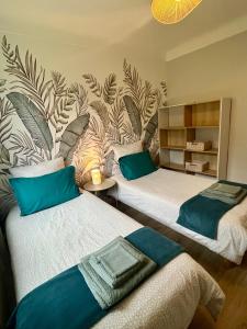 dwa łóżka w pokoju z malowidłem ściennym w obiekcie Villa Lila - Sarlat Centre piscine et jacuzzi w mieście Sarlat-la-Canéda