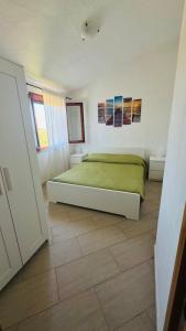 a bedroom with a bed on a wooden floor at Villa Arianna - Porto Pino in SantʼAnna Arresi