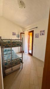 a bedroom with two bunk beds and a doorway at Villa Arianna - Porto Pino in SantʼAnna Arresi +9 photos