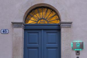 una porta blu con finestra su un edificio di P43 Sicilian Suites a Ragusa