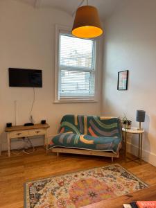 a living room with a couch and a television at Zen Beach House in Kent